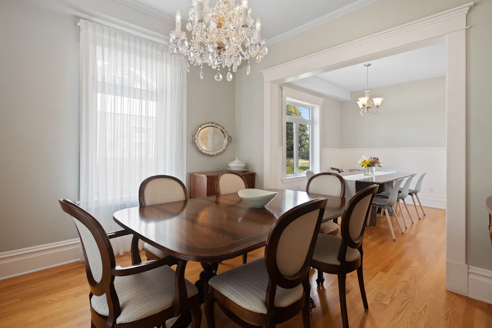 Traditional dining room with a crystal chandelier, wood table and upholstered chairs
