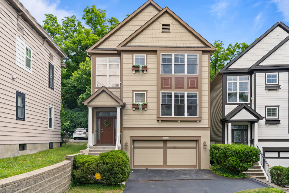 Three-story townhome with a covered entry and attached garage