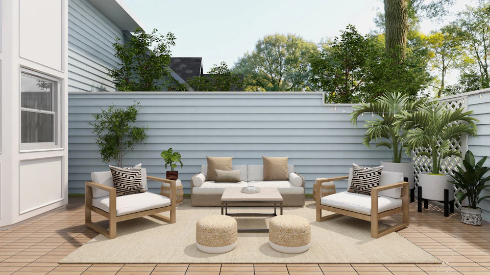 Patio staged with teak lounge chairs, a woven rug and potted palms