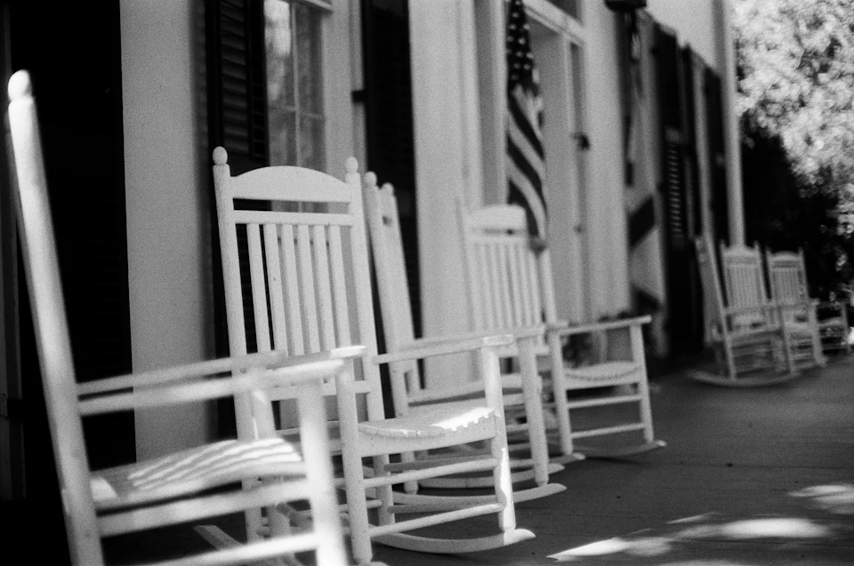Row of white rocking chairs on a classic Southern porch